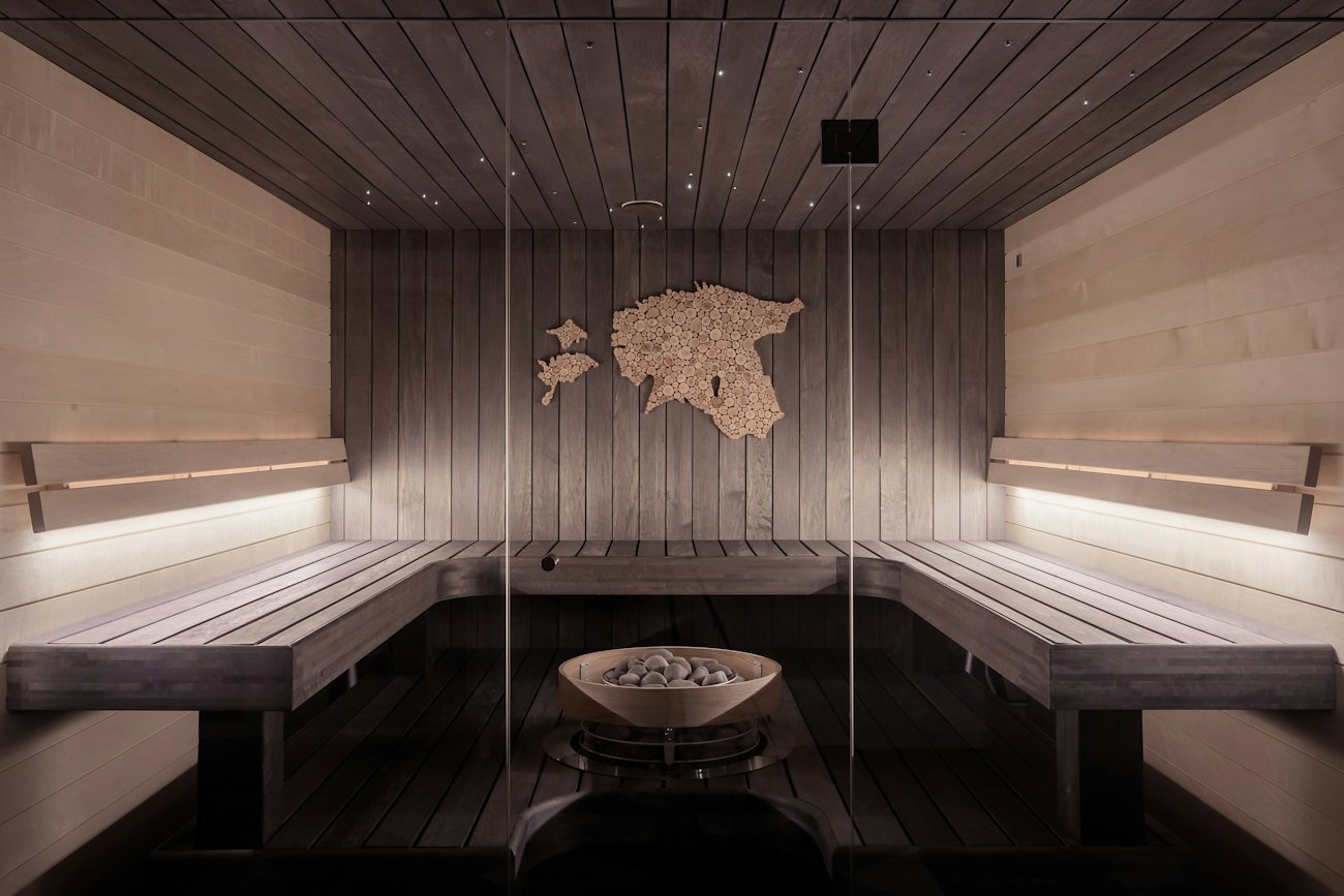 Inside a timber sauna with warm lighting along the benches